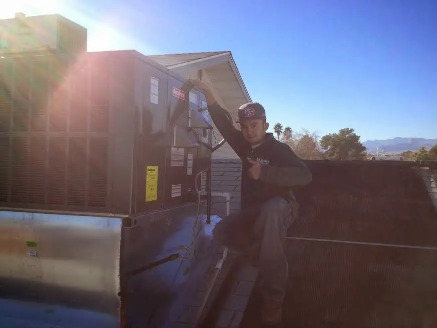 HVAC technician performing AC Tune-Up on a rooftop unit in Tumwater